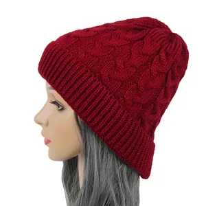 Side view of a premium burgundy cable-knit beanie featuring a warm and pointed top design