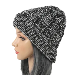 Side profile of a cozy black and white cable knit beanie hat shown on a mannequin head