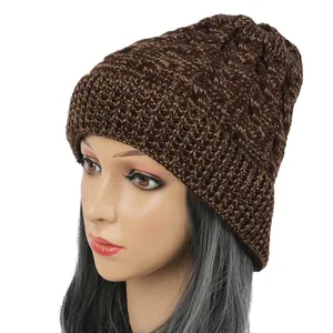 Detailed view of a brown cable-knit beanie hat on a mannequin showcasing warm winter texture