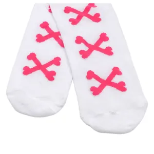 Détail de chaussettes hautes blanches avec des motifs d'os croisés de couleur rose vif