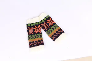Close-up of knitted fingerless sleeves with colorful snowflake and geometric patterns.
