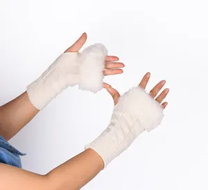Close-up detail of knitted fingerless gloves featuring a fluffy white faux fur trim.
