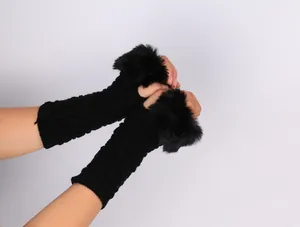 Close-up of black knitted half-finger gloves with plush faux fur trim on sleeves.