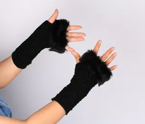 Close-up view of black cable-knit fingerless gloves featuring plush faux fur trim detail