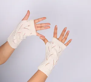 Vue détaillée de gants tricotés sans doigts blanc cassé avec motif ajouré élégant.