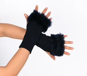 Detail of navy blue knitted fingerless gloves with faux fur trim worn by a model