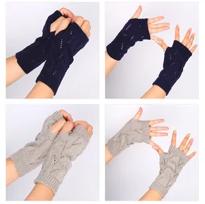 Détail de gants tricotés sans doigts avec un motif ajouré en bleu marine et gris
