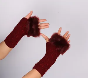 Close-up of wine red knitted fingerless gloves with plush faux fur trim detail