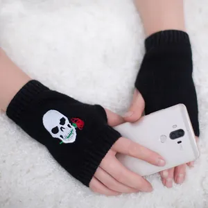 Dettaglio guanti senza dita in maglia nera con ricamo teschio e rosa per Halloween