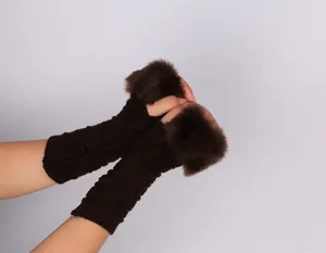 Detail of brown knitted fingerless arm warmers with plush faux fur trim for women.