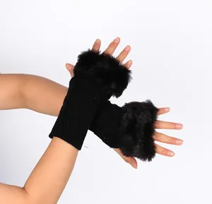 Close-up detail of black knitted fingerless gloves with plush faux rabbit fur trim