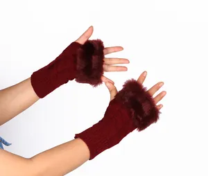 Close-up detail of wine red knitted fingerless gloves with soft and warm faux fur trim