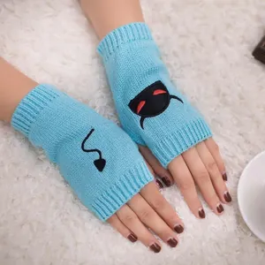 Detail showing embroidered devil face and tail on blue knitted fingerless gloves