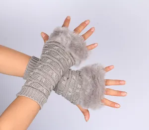 Detail of grey knitted fingerless gloves with butterfly pattern and faux fur trim.