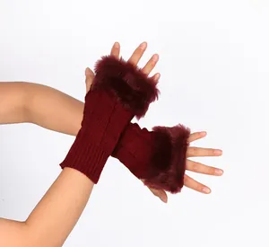 Macro detail of burgundy knitted fingerless gloves featuring plush wine red faux fur trim