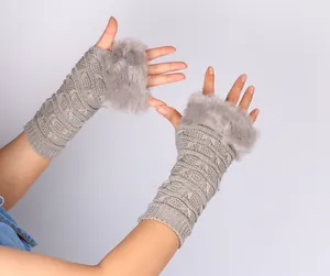 Close-up of grey knitted fingerless gloves with elegant faux fur trim and butterfly pattern