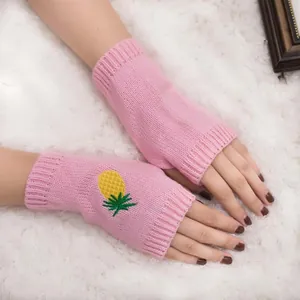 Gros plan de mitaines en maille rose avec un motif de broderie ananas très mignon.