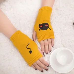 Close-up of yellow knitted fingerless gloves with black devil embroidery on white fur