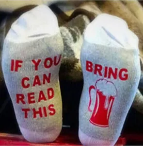 Close-up detail of cotton crew socks featuring humorous 'If you can read this' text on sole