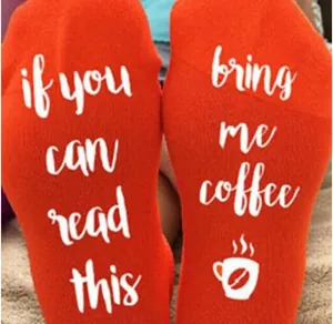 Detailed view of orange cotton socks with 'bring me coffee' printed on the bottom.