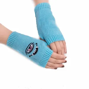 Detailansicht blauer Strickhandschuhe ohne Finger mit einzigartiger Monsterstickerei.