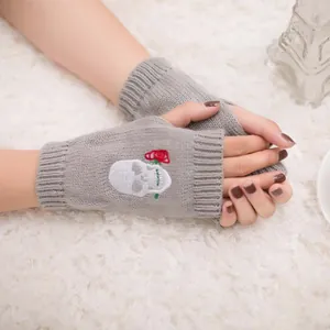 Primo piano di questi guanti in maglia grigi senza dita con ricamo teschio e rosa