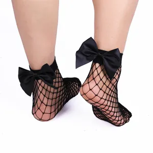 Dettaglio di calzini a rete corti da donna con un grande fiocco di raso nero sul retro.