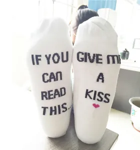 Detailed view of white cotton socks featuring funny English text printed on soles