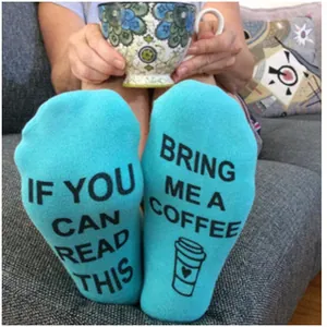 Close-up detail of light blue socks with funny English text Bring Me A Coffee