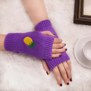 Gros plan de mitaines en tricot violettes avec un motif d'ananas brodé