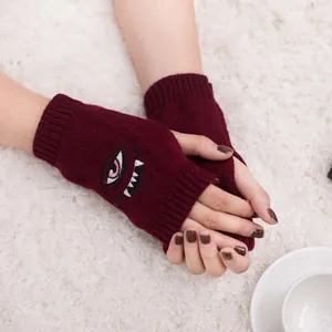 Detail von weinroten fingerlosen Handschuhen mit Monster-Augen-Stickerei im Harajuku-Stil.
