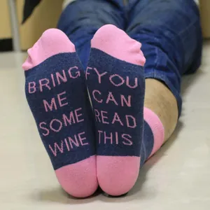 Detail of cotton socks with funny 'If you can read this bring me wine' text on soles