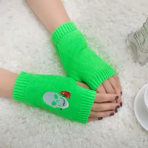 Guanti senza dita in maglia verde neon con ricamo di teschio e rosa per Halloween.
