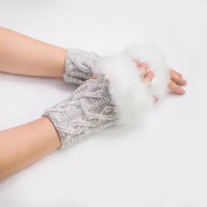 Vue détaillée de la bordure en fausse fourrure blanche et du tricot torsadé des mitaines.