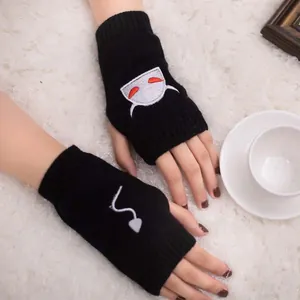 Macro view of black knitted fingerless gloves featuring cute Halloween devil embroidery