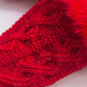 Gros plan sur la texture du gant en tricot rouge avec fil brillant et fourrure
