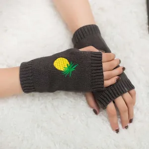 Vue détaillée de la broderie ananas sur les mitaines en maille gris foncé pour femme