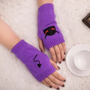 Close-up detail of purple knitted fingerless gloves featuring cute devil embroidery