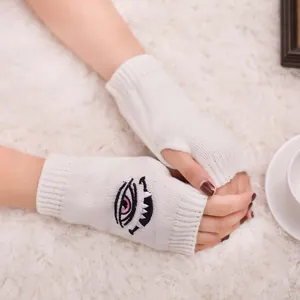 Detailansicht der Harajuku-Augenstickerei auf gemütlichen weißen stricklosen Handschuhen