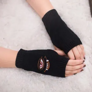Nahaufnahme der Monster-Augenstickerei auf schwarzen Strickhandschuhen mit weicher Textur