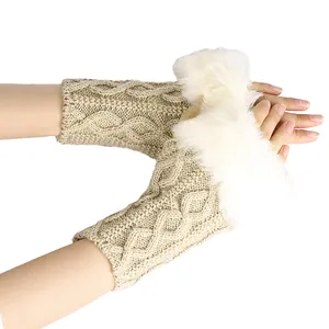 Détail des mitaines en maille torsadée avec bordure en fausse fourrure blanche.
