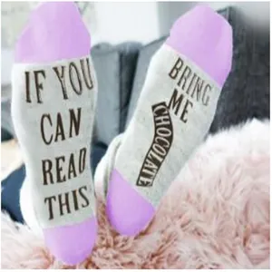 Detail view of humorous white and purple socks with bring me chocolate text design