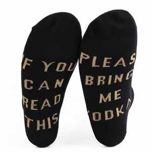 Close-up of black cotton ankle socks featuring humorous knitted 'Bring me Vodka' text