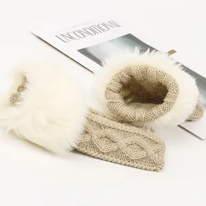 Gros plan de mitaines en tricot beige avec bordure en fausse fourrure blanche et fil brillant.