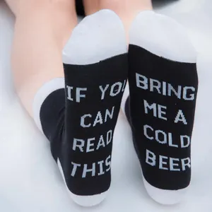Detail of cotton socks with 'If you can read this bring me a cold beer' text on soles.
