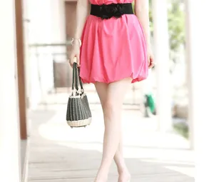 Close-up detail view of a black elastic waist belt with floral accents on a pink dress.