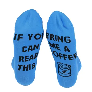 Detailed macro view of humorous Bring Me A Coffee message printed on blue cotton sock soles