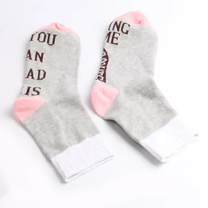 Close-up detail of grey and pink novelty socks with chocolate slogan print design