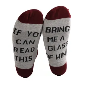 Detailed view of grey cotton socks featuring funny 'Bring me wine' text on soles