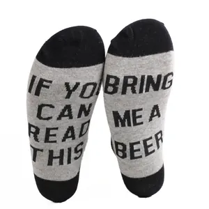 Detailed close-up of gray cotton socks with 'Bring Me a Beer' text printed on the soles.